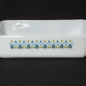 Puede incluir: Molde para pan de cerámica blanca con un diseño floral azul y verde alrededor del borde.