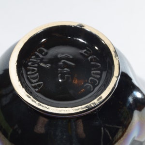 May include: Black ceramic teapot with a gold rim and the words "Renucci" and "Canada" on the bottom.