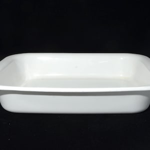 Peut inclure: Un plat de cuisson rectangulaire blanc aux coins arrondis et à la finition lisse et brillante. Le plat présente un large bord plat qui s'étend vers l'extérieur depuis les côtés verticaux, créant un design épuré pour la préparation culinaire.