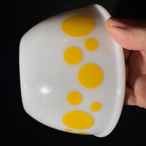 May include: White ceramic bowl with yellow polka dots.