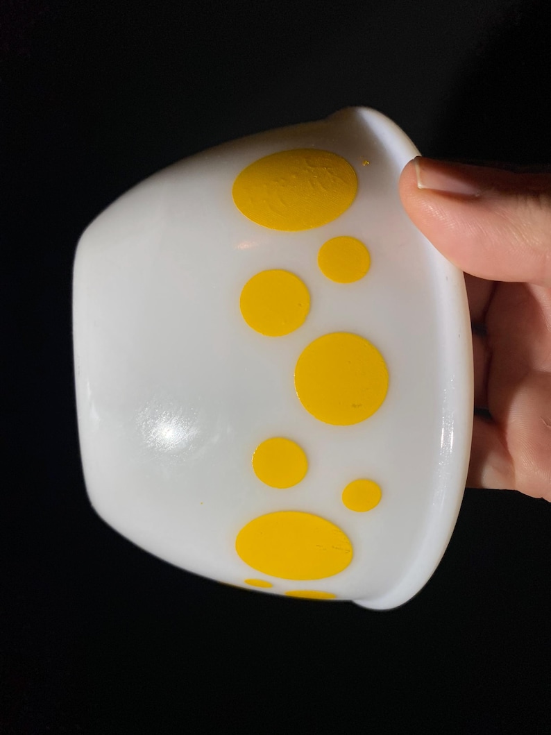 May include: White ceramic bowl with yellow polka dots.