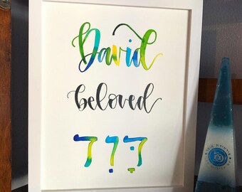 May include: A white framed print with the name "David" written in colourful script, followed by the word "beloved" in black script. The number "777" is written in colourful script below the words.