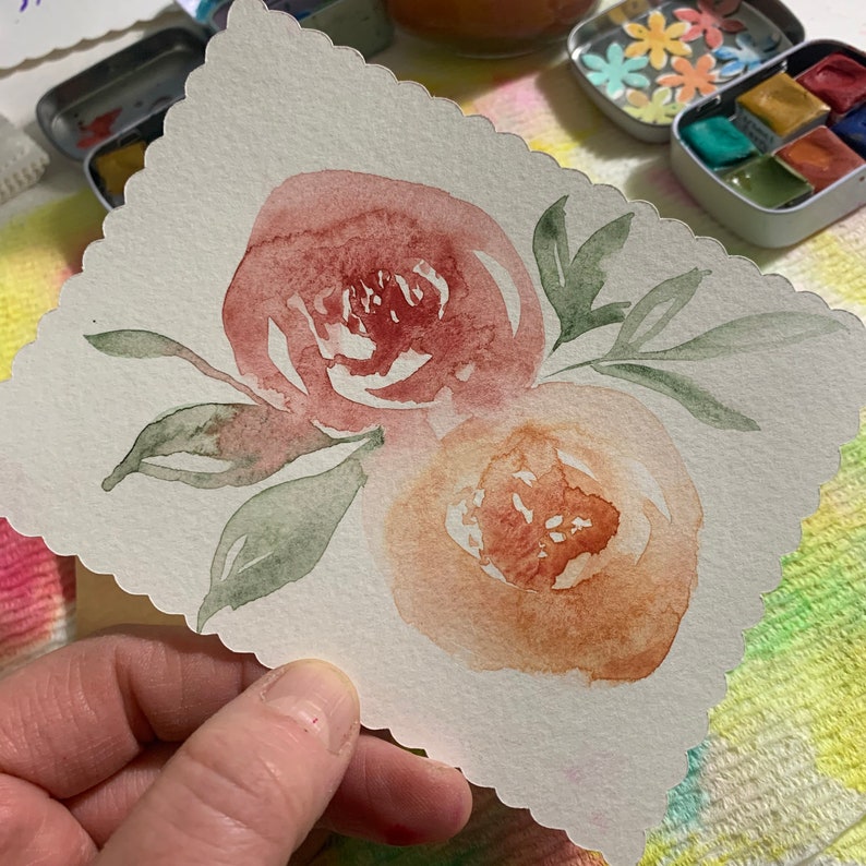 May include: A watercolor painting of two pink and orange flowers with green leaves on a white background.