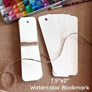 May include: A stack of 7.5" x 2" white watercolor bookmarks with a hole punched in the top. The bookmarks are tied together with twine.