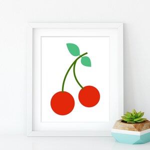 May include: A white framed print with a simple illustration of two red cherries with green stems and leaves.
