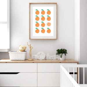 May include: A framed print with a white background and a pattern of orange fruit. The fruit is arranged in rows with one orange slice in the center.