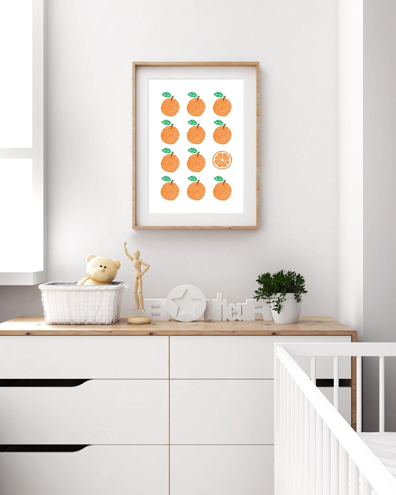 May include: A framed print with a white background and a pattern of orange fruit. The fruit is arranged in rows with one orange slice in the center.