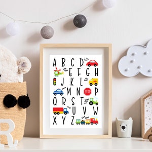May include: A black and white alphabet chart with colorful illustrations of vehicles, including a helicopter, a car, a traffic light, an ambulance, a tractor, a truck, and a train. The letters are in uppercase and are arranged in alphabetical order.