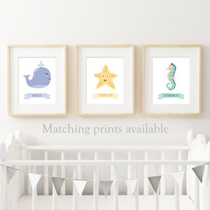 May include: Three framed prints with illustrations of a whale, starfish, and seahorse. Each print has a light blue banner with the name of the animal written in black.