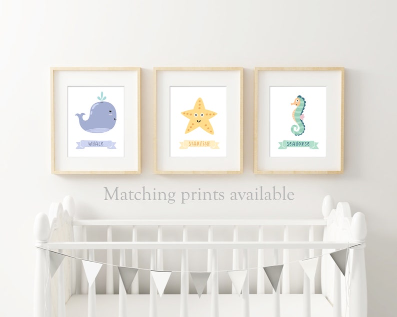 May include: Three framed prints with illustrations of a whale, starfish, and seahorse. Each print has a light blue banner with the name of the animal written in black.