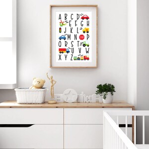 May include: A white framed alphabet chart with colorful illustrations of vehicles and transportation. The letters are black and the words below each letter are in a smaller font. The letters are A through Z.