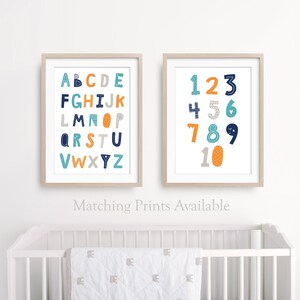 May include: Two framed prints with a white background. The left print features the alphabet in blue, orange, and gray letters. The right print features the numbers 1-10 in blue, orange, and gray numbers.