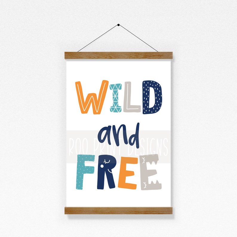 May include: A white canvas print with a wooden frame. The print features the text "WILD and FREE" in colorful, stylized letters with geometric patterns.