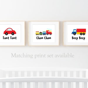 May include: Three framed prints with illustrations of a red car, a train, and a truck. The prints have the text "Toot Toot", "Choo Choo", and "Beep Beep" underneath the illustrations.