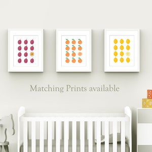 May include: Three white framed prints with a grid of fruit illustrations. The prints feature plums, oranges, and lemons. One fruit in each grid is cut in half to show the inside.