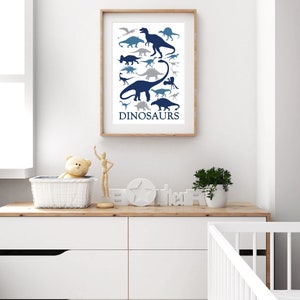 May include: A framed print with a white background and blue dinosaur silhouettes. The print has the word "DINOSAURS" at the bottom.