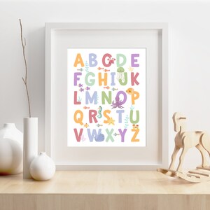 May include: A white framed print with a colorful alphabet featuring sea creatures. The letters are in different colors and each letter has a different sea creature next to it. The letters are A-Z.