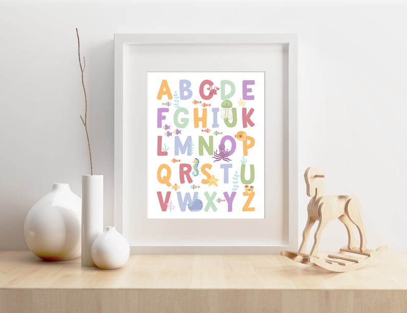 May include: A white framed print with a colorful alphabet featuring sea creatures. The letters are in different colors and each letter has a different sea creature next to it. The letters are A-Z.