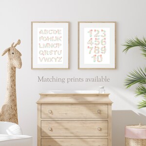 May include: Two framed prints with a white background. The left print features the alphabet in a floral design. The right print features the numbers 1-10 in a floral design. The text "Matching prints available" is below the prints.