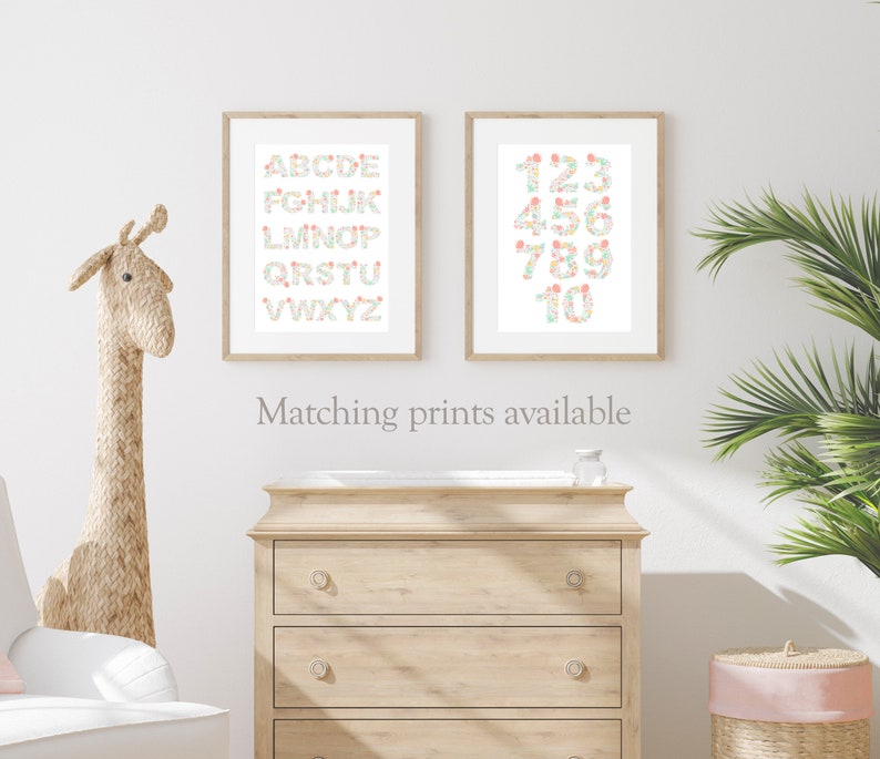 May include: Two framed prints with a white background. The left print features the alphabet in a floral design. The right print features the numbers 1-10 in a floral design. The text "Matching prints available" is below the prints.