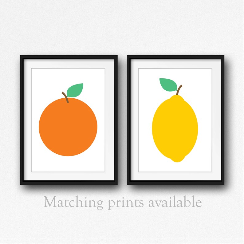 Puede incluir: Dos impresiones enmarcadas, una con un lim&oacute;n amarillo y otra con una naranja naranja, ambas con hojas verdes. Las impresiones tienen fondos blancos y marcos negros. El texto "Impresiones a juego disponibles" est&aacute; debajo de los marcos.