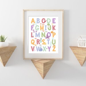 May include: A colorful alphabet poster with sea creatures. The letters are in a rainbow of colors and each letter has a different sea creature next to it. The poster is framed in a light wood frame.
