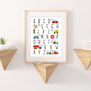 May include: A white alphabet chart with colorful illustrations of vehicles for each letter. The letters are in black and the illustrations include a helicopter, traffic light, car, ambulance, truck, tractor, train, and a red car.