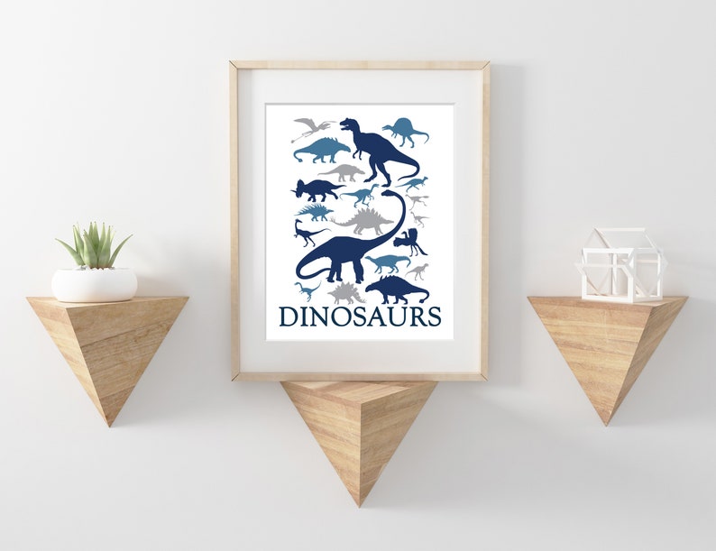 May include: A framed print with a white background and blue and gray dinosaur silhouettes. The print has the word "DINOSAURS" at the bottom.