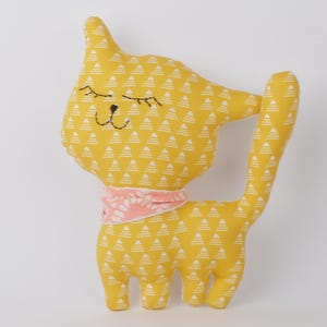 Cuscino gatto di Doudou, tessuto stampato piccoli triangoli su sfondo giallo senape.