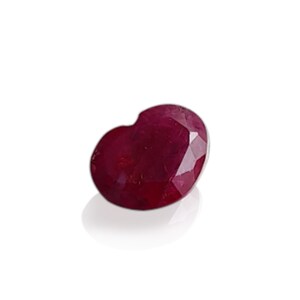 May include: A heart-shaped ruby gemstone with a deep red color.