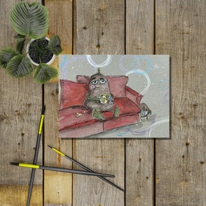 May include: A watercolour illustration of a brown potato character sitting on a red sofa with a yellow object in its hand. The potato character has a surprised expression on its face. The background is a light blue with white circles.