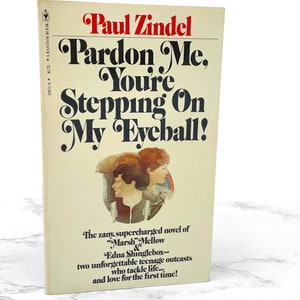 May include: A vintage paperback book cover with a yellow background and black text. The title is "Pardon Me, You're Stepping On My Eyeball!" by Paul Zindel. The cover features a black and white illustration of two teenagers.