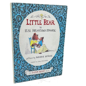 May include: A vintage children's book titled "Little Bear" by Else Holmelund Minarik, with illustrations by Maurice Sendak. The cover features a bear and cub illustration within a white oval, surrounded by a blue floral design. Published by Harper & Row.