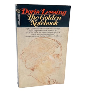 May include: A vintage paperback book titled "Doris Lessing The Golden Notebook." The cover features a portrait sketch of a woman in profile, with text in red and gold. The back cover includes a quote from The New York Times Book Review.