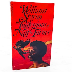May include: A vintage book cover with the title "The Confessions of Nat Turner" by William Styron. The cover is predominantly red with black lettering and a portrait of a man. A figure with wings is also depicted.