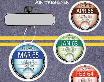 May include: Four round novelty replica car tax discs, each with a different month and year. The discs are white with blue, green, red, and brown colored text. The text on the discs reads "APR 66", "MAR 65", "JAN 63", and "FEB 64". The discs are hanging from a string.