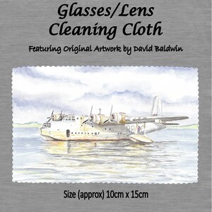 May include: A watercolor painting of a white seaplane with red, white, and blue markings on the water. The painting is on a white cleaning cloth with the text "Glasses/Lens Cleaning Cloth Featuring Original Artwork by David Baldwin" and "Size (approx) 10cm x 15cm".