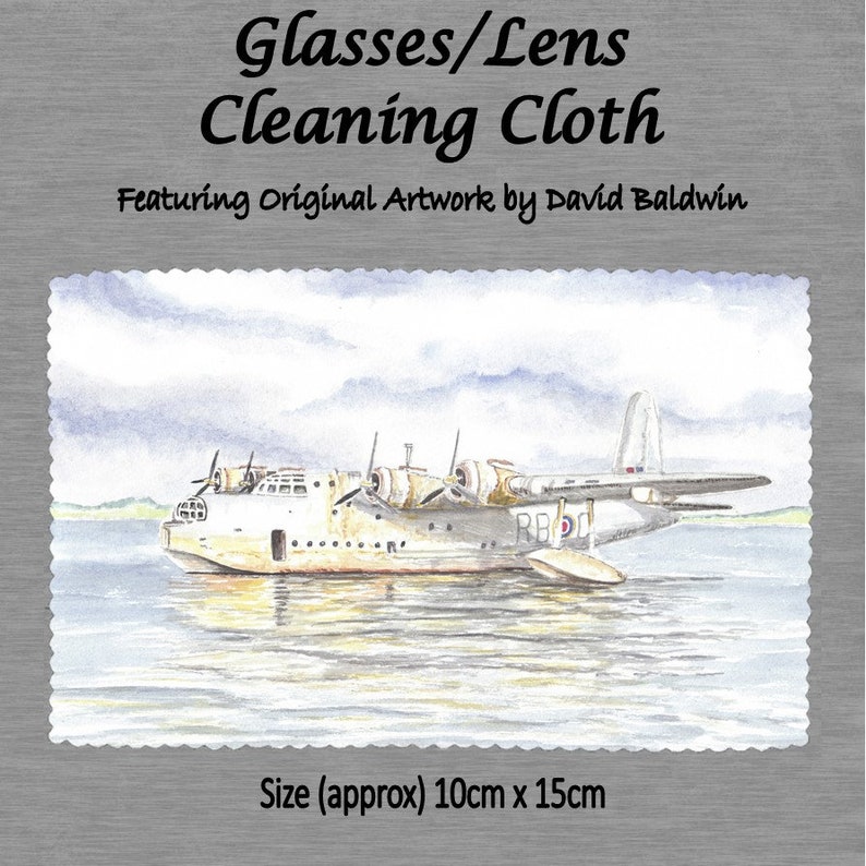 May include: A watercolor painting of a white seaplane with red, white, and blue markings on the water. The painting is on a white cleaning cloth with the text "Glasses/Lens Cleaning Cloth Featuring Original Artwork by David Baldwin" and "Size (approx) 10cm x 15cm".