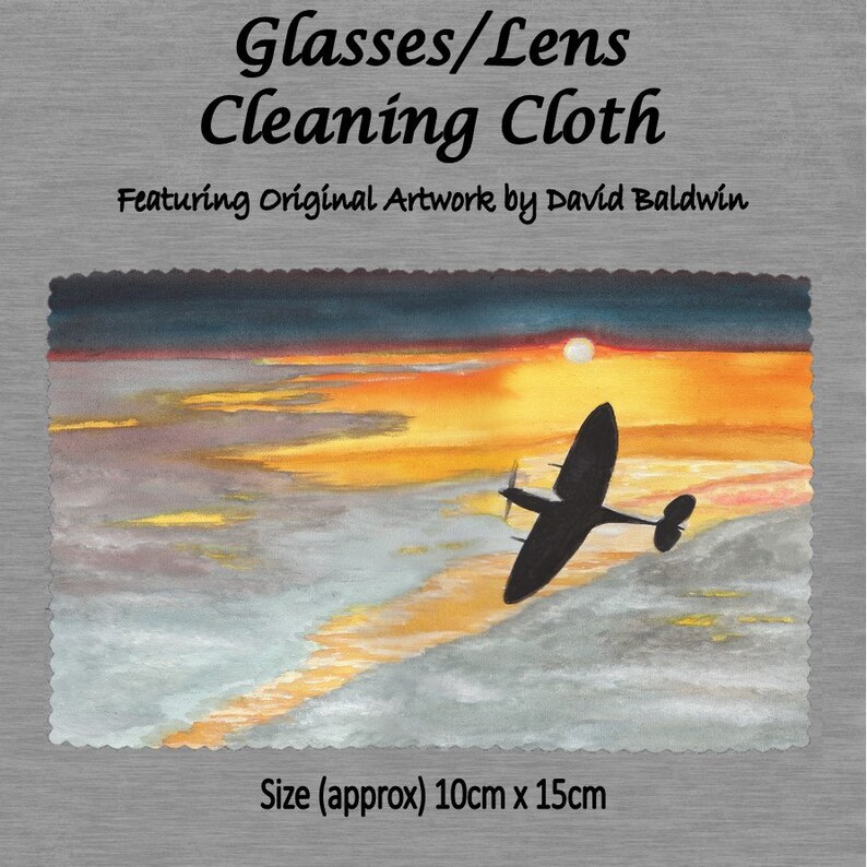May include: A microfiber cleaning cloth featuring an original watercolor painting of a silhouette of a vintage airplane flying over a sunset. The text "Glasses/Lens Cleaning Cloth" and "Featuring Original Artwork by David Baldwin" is printed on the top of the cloth. The cloth measures approximately 10 inches by 15 inches.
