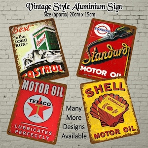 Puede incluir: Cuatro letreros de metal de estilo vintage que anuncian diferentes aceites para motores. Los letreros son rojos, amarillos y azules con letras blancas. Los letreros miden aproximadamente 20 cm por 30 cm.