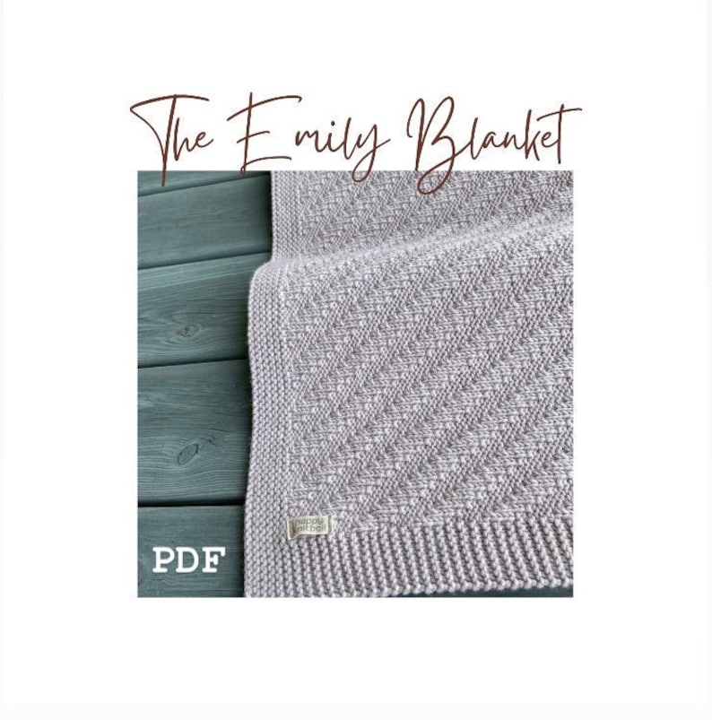 May include: A close-up of a light gray knitted blanket with a subtle diamond pattern. The blanket is folded in half and has a small white tag with the text "The Emily Blanket" on it. The blanket is on a dark green wooden surface. The text "PDF" is visible in the lower left corner of the image.
