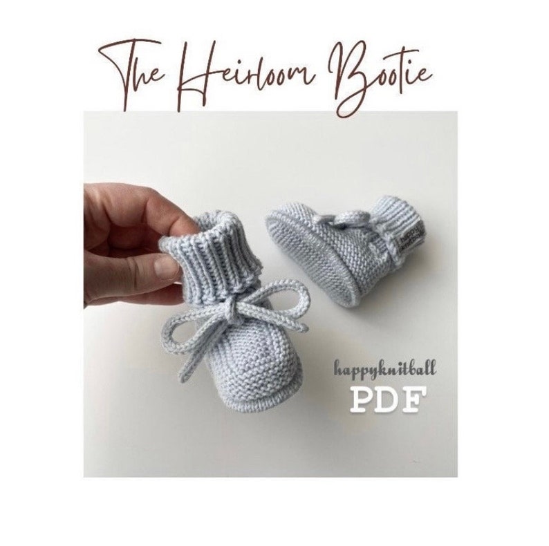 May include: A pair of light gray knitted baby booties with a ribbed cuff and a tied bow detail. The text "The Heirloom Bootie" appears at the top, and "happyknitball PDF" is printed in the lower right corner of the image.