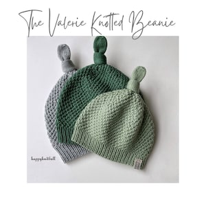 Può includere: Tre berretti a maglia in diverse tonalità di verde e grigio. I berretti hanno una cima annodata e sono realizzati con una maglia testurizzata. Il testo "happyknitball" è visibile nell'angolo in basso a sinistra.