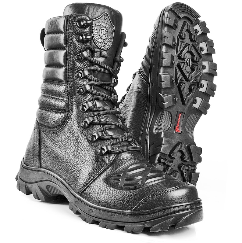 Puede incluir: Botas de cuero negro con cierre de cordones y suela gruesa de goma. Las botas tienen un cuello acolchado y un logotipo en el lateral que dice "BM Brasil".