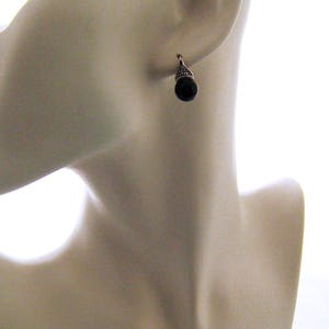 May include: A pair of silver earrings with black teardrop-shaped stones.