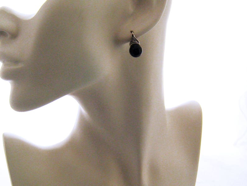 May include: A pair of silver earrings with black teardrop-shaped stones.
