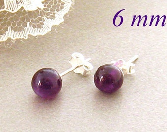 May include: A pair of silver stud earrings with 6 mm round purple amethyst gemstones.