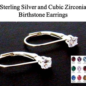May include: Sterling silver earrings with a cubic zirconia birthstone. The earrings are shown on a black background. A chart of birthstones is shown below the earrings.
