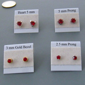 May include: Four cards with red gemstone earrings on white cardstock. The cards are labeled with the earring style and size: Heart 5 mm, 5 mm Prong, 3 mm Gold Bezel, and 2.5 mm Prong.