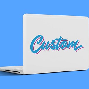 Puede incluir: Ordenador port&aacute;til blanco con la palabra "Custom" en una fuente de escritura turquesa y morada en la tapa. El port&aacute;til est&aacute; abierto, mostrando el teclado y el panel t&aacute;ctil. El fondo es azul liso.